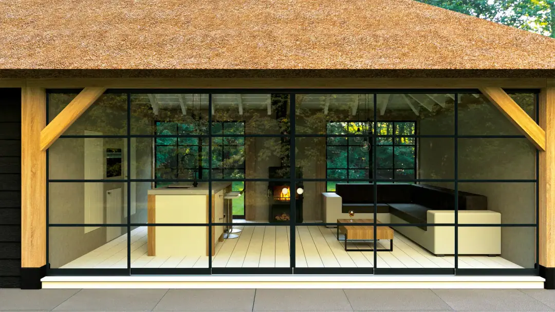 Szklana ściana z czarnymi profilami Steellook w stylu loft zamykająca pokój ogrodowy pod dachem krytym strzechą