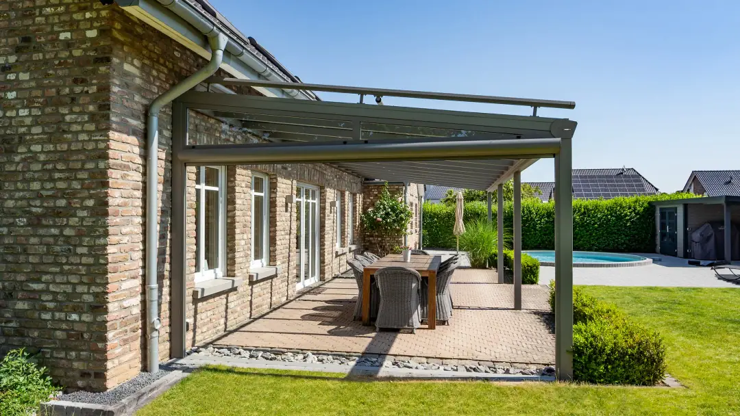 Trendstyle w kolorze szarego aluminium ze szklanym dachem i okrągłą rynną nad jadalnią, w tle basen