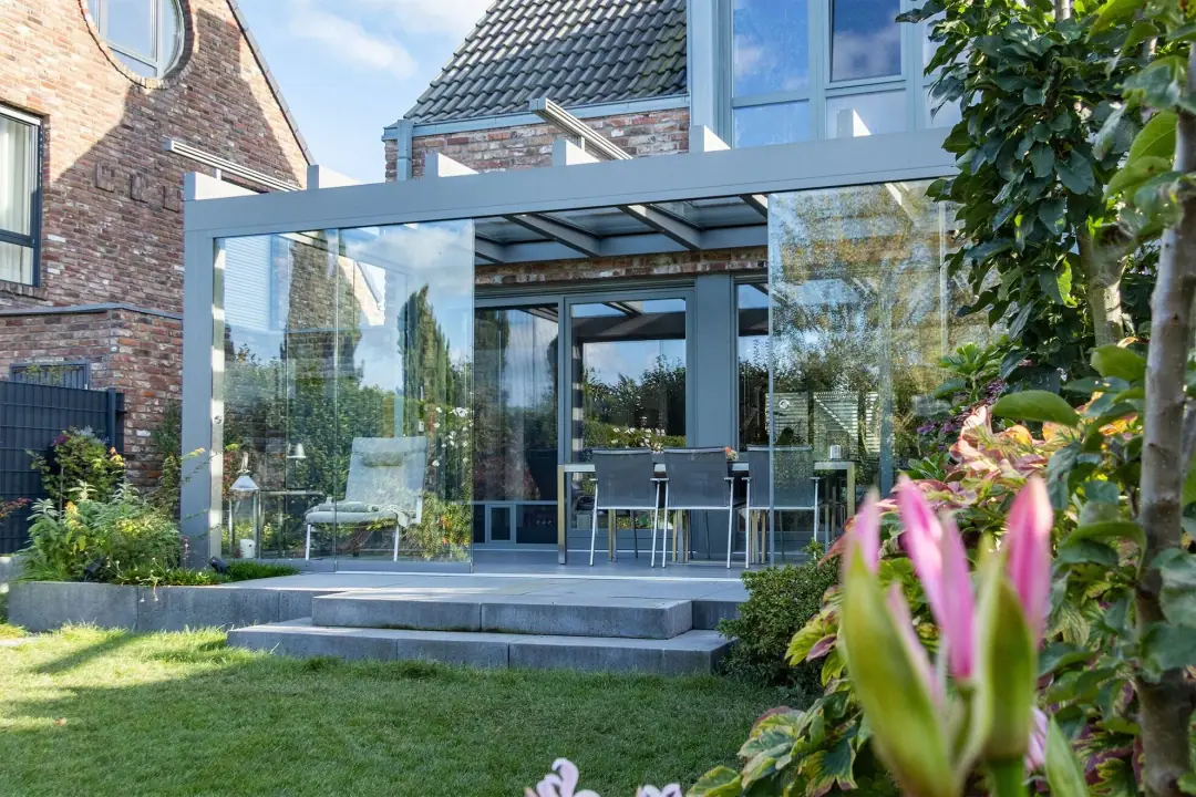 Ultrastyle Compact w kolorze szarego aluminium ze ścianami panoramicznymi i markizą naddachową